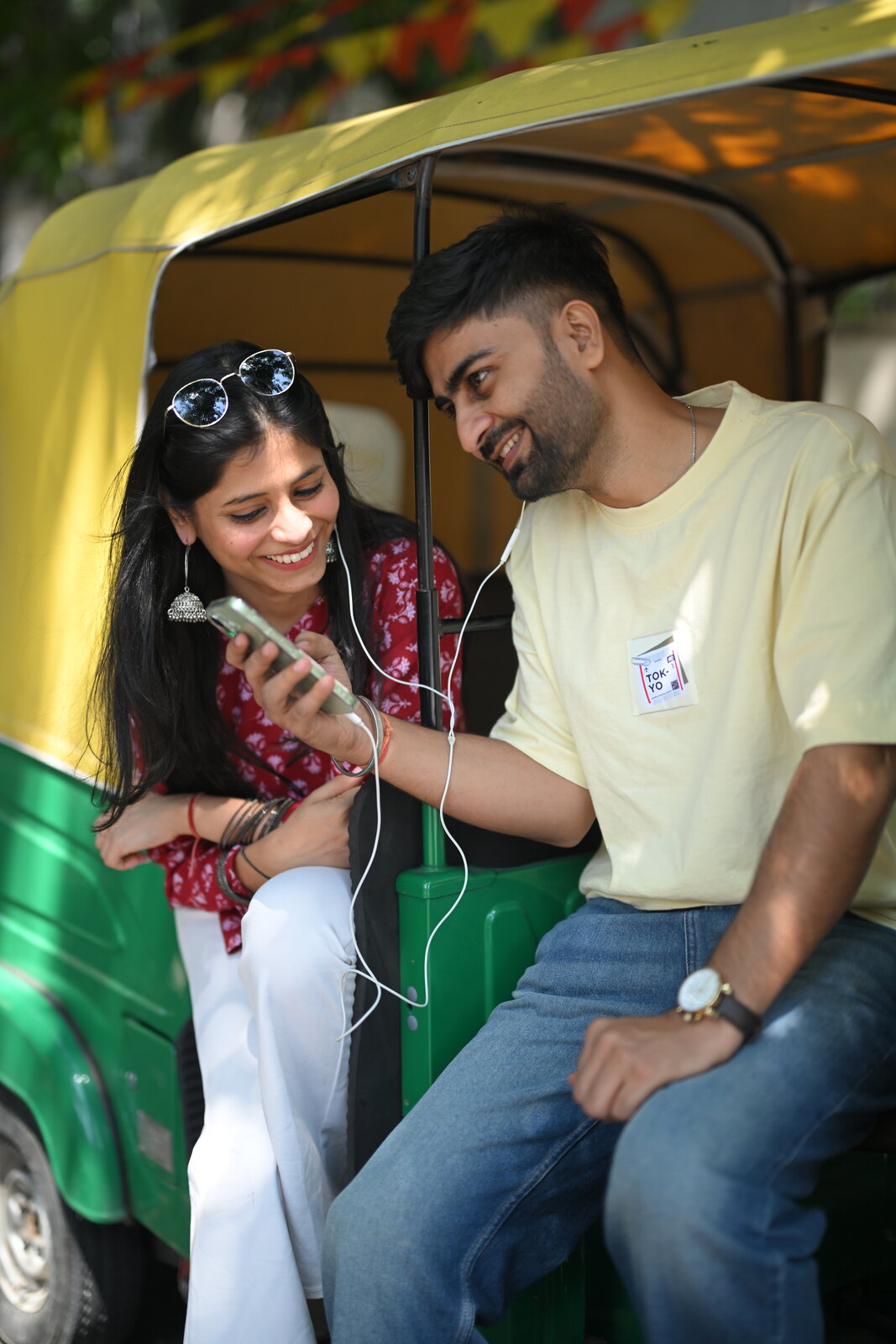 Priya and Ashish sharing music and candid laughter in an auto-rickshaw
